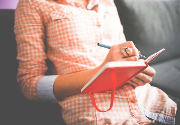 زنی جملات انگیزشی را در دفترچهاش یادداشت میکند